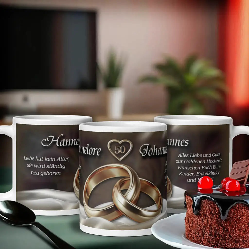 Motivtasse Goldene Hochzeit mit goldenen Ringen, Namen und Zahl 50, auf Tisch mit Kuchen