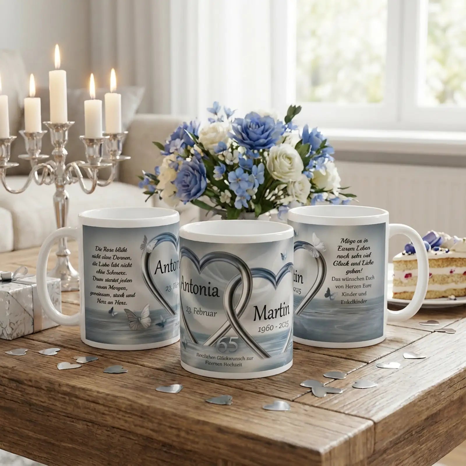 Personalisierte Motivtassen zur Eisernen Hochzeit mit silbernen Herzringen, Namen Antonia und Martin, Jahreszahlen 1960–2025, Zahl 65, festlich arrangiert auf Holztisch mit blauen Rosen, Kerzenleuchtern und Kuchenteller
