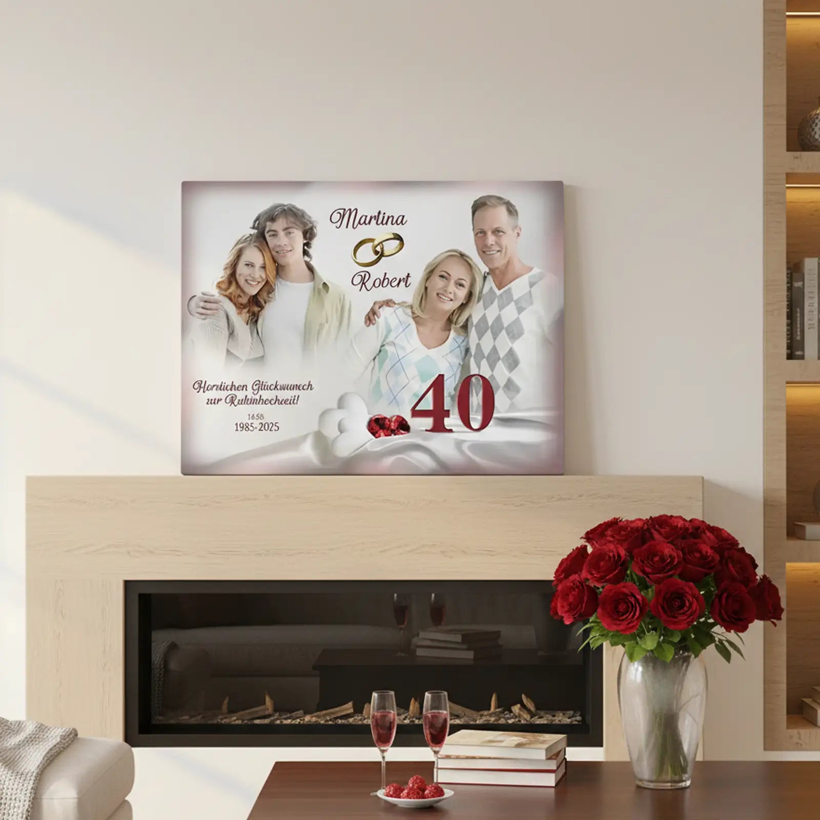 Personalisierte Fotoleinwand zur Rubinhochzeit (40 Jahre Ehe), auf einem Kaminsims in einem modernen Wohnzimmer platziert. Die Leinwand zeigt zwei Paarfotos: links das Ehepaar in jungen Jahren, rechts das Ehepaar im heutigen Alter. In der Mitte stehen die Namen „Martina“ und „Robert“ mit zwei goldenen Eheringen. Darunter ist die Zahl 40 in Rot sowie der Glückwunsch zur Rubinhochzeit mit den Jahreszahlen 1985–2025. Im Vordergrund des Raumes stehen zwei Gläser Sekt und eine Vase mit roten Rosen.