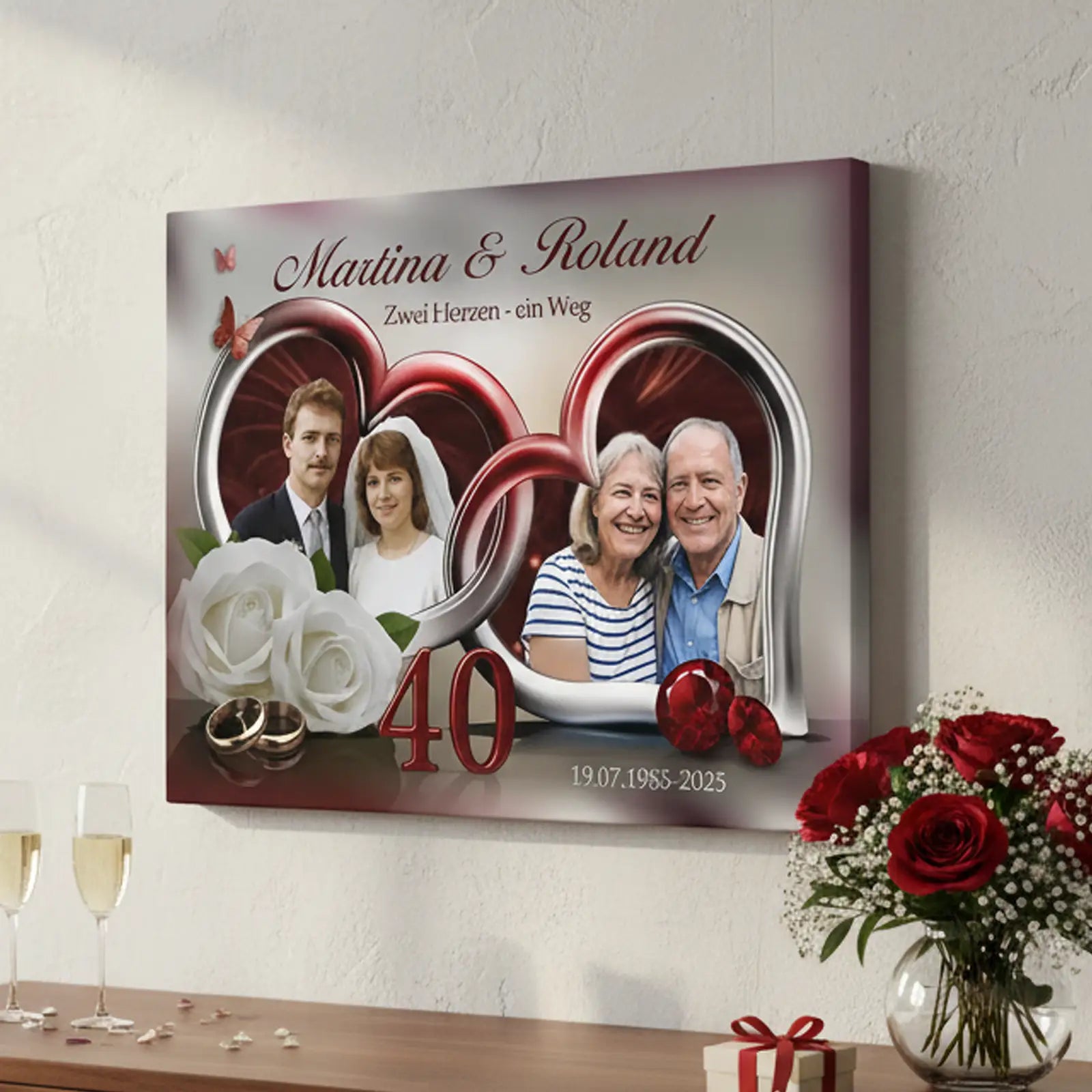 Personalisierte Fotoleinwand zur Rubinhochzeit (40 Jahre) mit Fotodruck eines Ehepaares aus zwei Lebensphasen. Auf der Leinwand sind die Namen Martina und Roland, herzförmige Rahmen, weiße Rosen, goldene Trauringe, rote Schmucksteine sowie die Jubiläumszahl 40 mit dem Datum 19.07.1985–2025 zu sehen. Die Leinwand hängt an einer Wand, darunter stehen zwei Sektgläser, rechts daneben steht ein Blumenstrauß mit roten Rosen. Geschenk zum 40. Hochzeitstag.