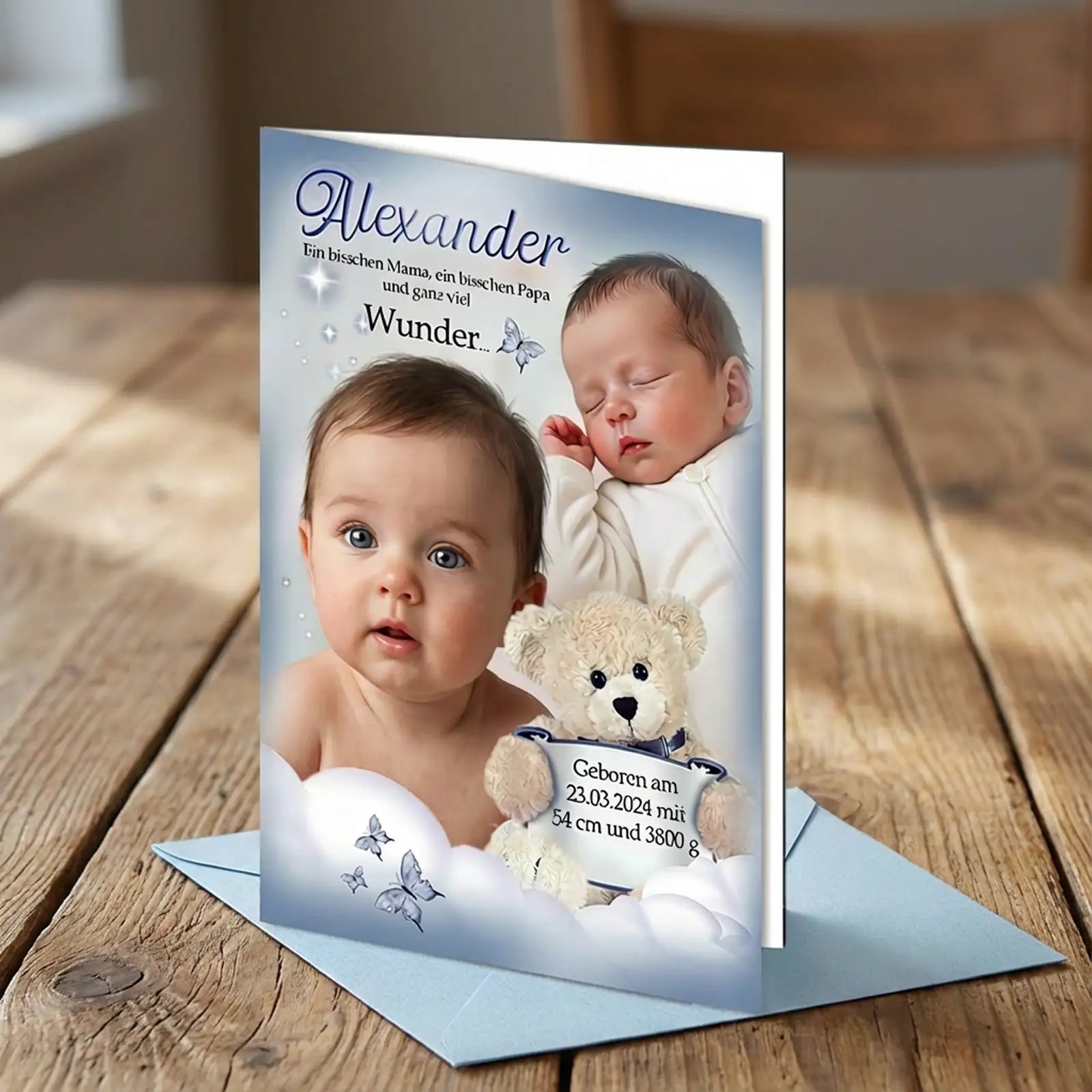 Personalisierte Baby-Geburtskarte für Jungen – blaues Design mit Foto, Name Alexander, Geburtsdaten und blauem Umschlag, präsentiert auf rustikalem Holztisch.