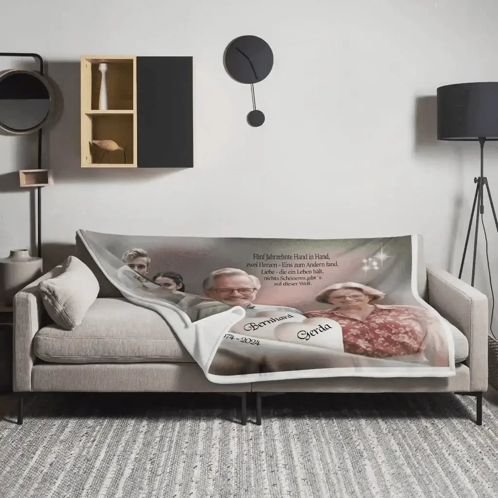 Personalisierte Wolldecke Goldhochzeit mit Fotos und Namen auf grauem Sofa im Wohnzimmer