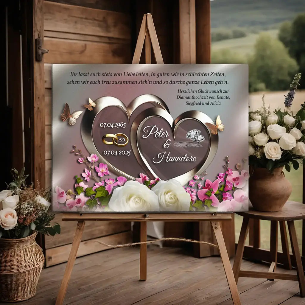 Diamanthochzeit Leinwand mit Herzmotiv, Namen, Datum und Blumen, auf Staffelei dekoriert.
