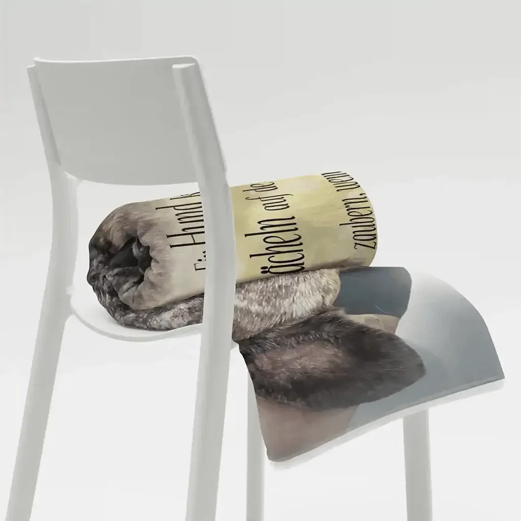 Flauschige Haustierdecke mit Schriftzug, zusammengerollt auf weißem Stuhl, grau-beige Design