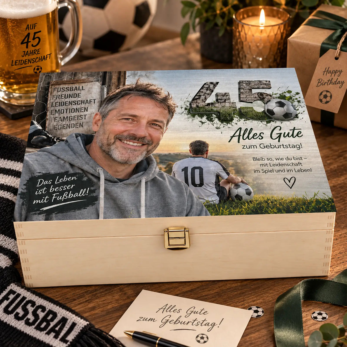 Personalisierte Holzbox zum 45. Geburtstag für Fußballfans, dekorativ in einer stimmungsvollen Geschenk-Szene arrangiert. Auf dem Deckel ist eine Geburtstagscollage mit Männerporträt, Fußballmotiv, der Zahl 45 und dem Text „Alles Gute zum Geburtstag“ zu sehen.