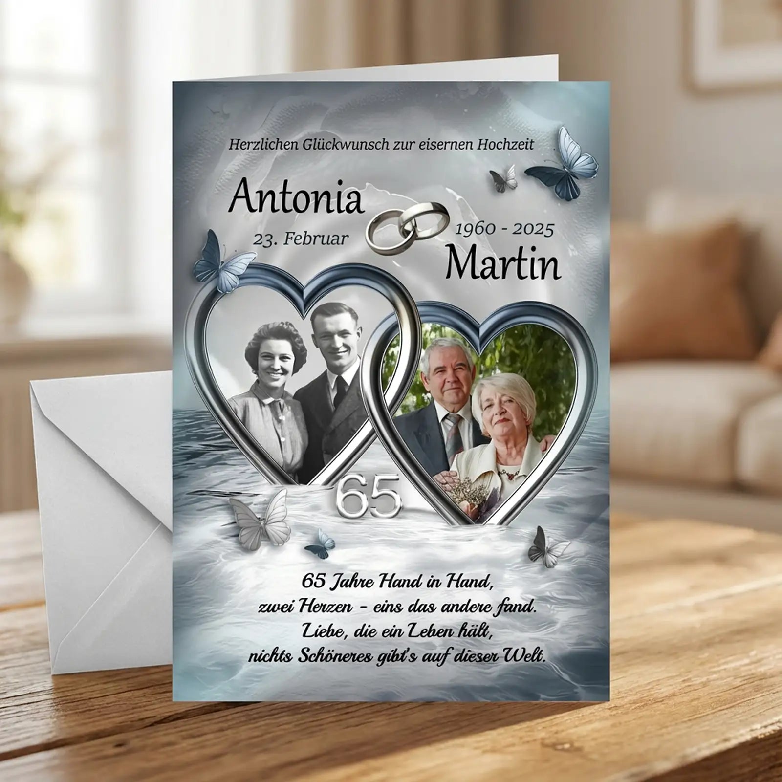 Personalisierte Glückwunschkarte zur Eisernen Hochzeit mit zwei ineinander verschlungenen Herzrahmen, altes Schwarzweiß-Hochzeitsfoto und aktuelles Paarfoto von Antonia und Martin, Datum 23. Februar, Jahreszahlen 1960–2025, Zahl 65, silberne Eheringe, Schmetterlinge, romantischer Hochzeitsspruch über lebenslange Liebe, maritimer Hintergrund in sanften Blau- und Grautönen, festliche Tischszene mit Umschlag.