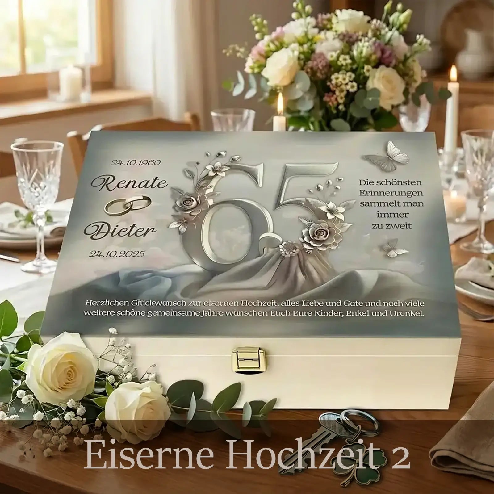 Personalisierte Holzbox zur Eisernen Hochzeit mit hellem Holz und Metallverschluss. Auf dem Deckel ist die Zahl 65 in silberner Optik mit floralen Elementen und Schmetterlingen gestaltet, ergänzt durch die Namen Renate und Dieter sowie die Jubiläumsdaten. Die Box steht auf einer festlich gedeckten Tafel mit Blumen, Kerzen und Gläsern und vermittelt eine elegante, feierliche Atmosphäre.