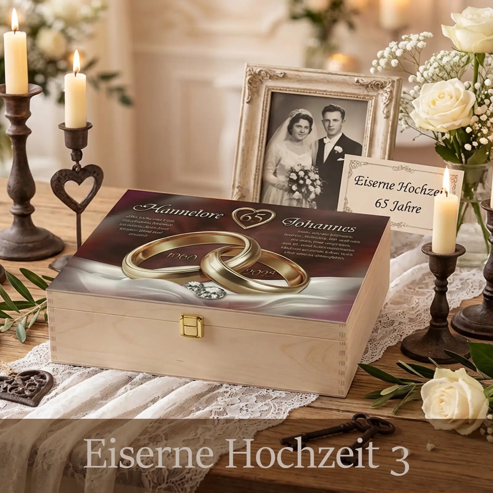 Personalisierte Holzbox zur Eisernen Hochzeit mit hellem Holz und Metallverschluss. Auf dem Deckel sind zwei goldene Eheringe mit der Zahl 65 sowie die Namen Hannelore und Johannes und die Jubiläumsjahre gestaltet. Die Box steht auf einer festlich dekorierten Tafel mit Kerzen, weißen Rosen, Spitze und einem gerahmten Hochzeitsfoto und vermittelt eine würdige, nostalgische Atmosphäre zum 65. Hochzeitstag.
