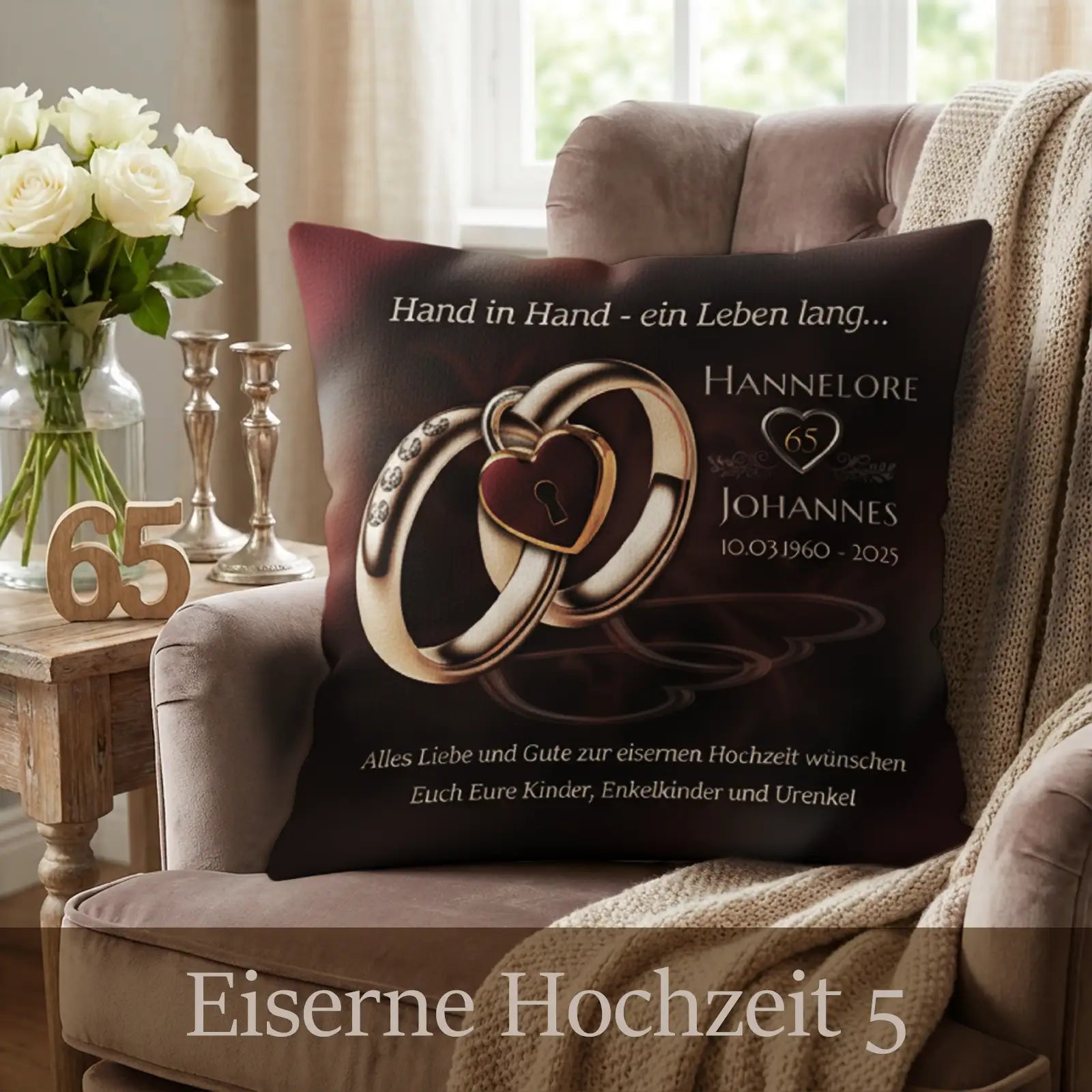 Kissen zur Eisernen Hochzeit mit dunklem Bordeaux-Braunton, zwei ineinanderliegenden Ringen mit Herz-Schloss-Motiv, personalisierten Namen Hannelore und Johannes, Zahl 65 und Datumsangaben, dekoriert auf Polstersessel mit Kerzenständern, Holzbeistelltisch und Wohnzimmer-Ambiente