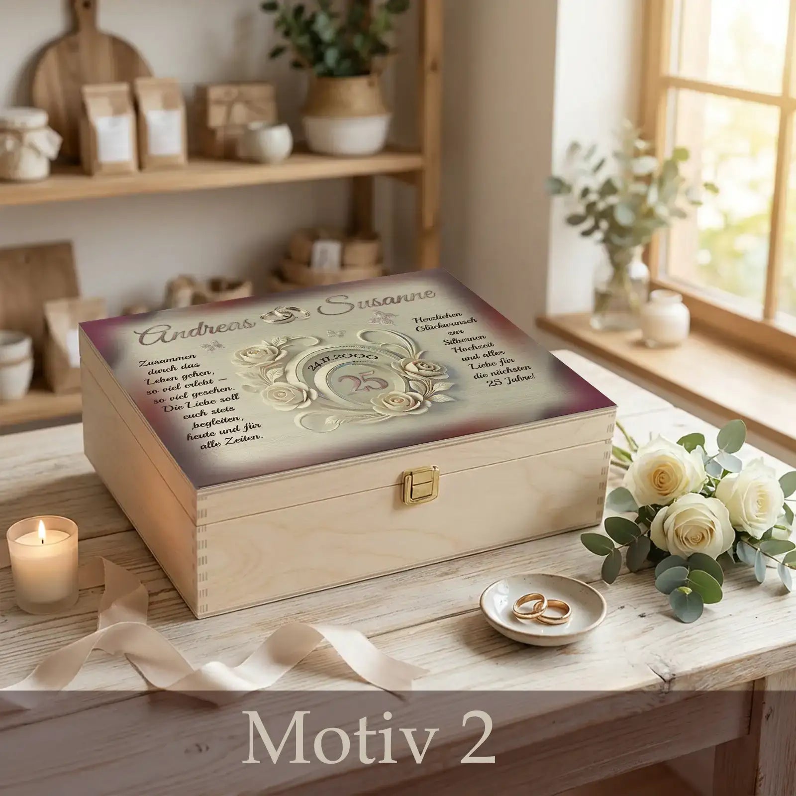 Personalisierte Holzbox zur Silberhochzeit mit Namen des Ehepaares, Hochzeitsdatum und 25-Jahre-Motiv, arrangiert auf hellem Holztisch mit Eheringen, weißen Rosen, Kerze und Stoffband.